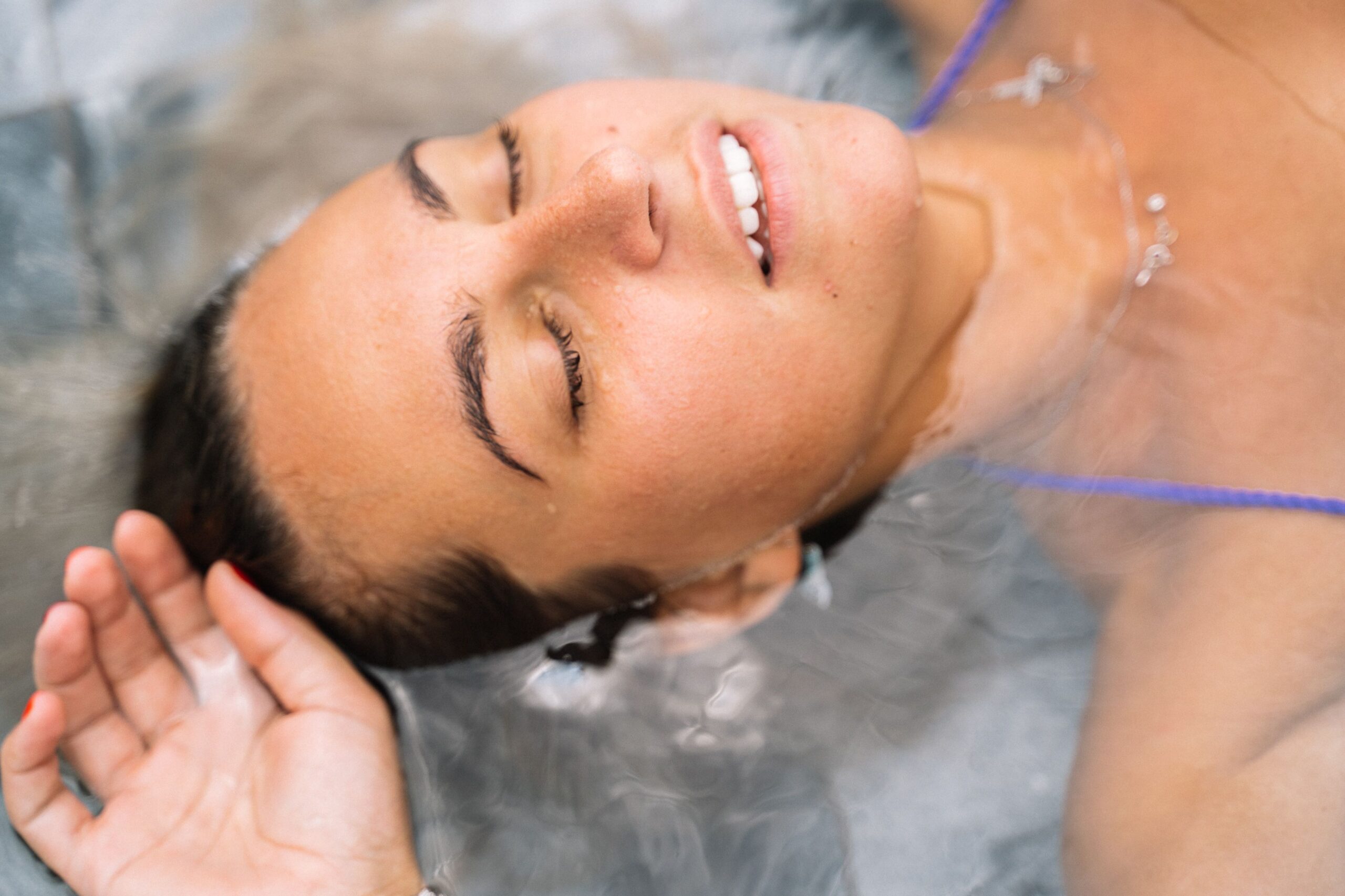 Woman floating peacefully with eyes closed during a float therapy session